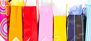 Row of colorful shopping bags isolated on white background