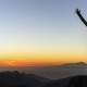 Woman successful hiking climbing silhouette in mountains, motivation and inspiration in beautiful sunset and ocean. Female hiker with arms up outstretched on mountain top looking at beautiful night sunset inspirational landscape.